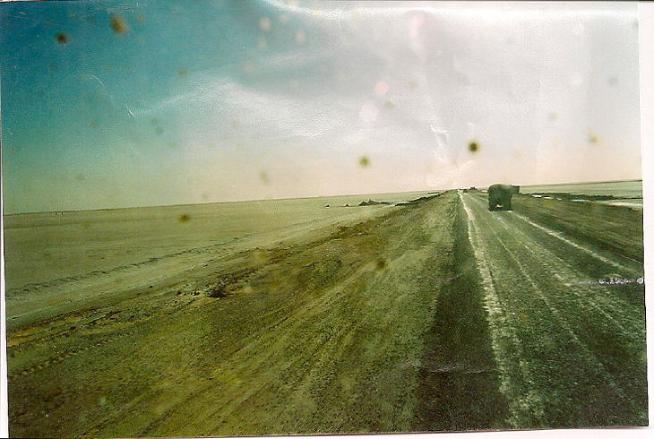 Auf einer Straße über einen Salzsee im Süden Tunesiens; aus einem Fotoalbum mit allen Alterungsspuren des Papierfotos eingescannt